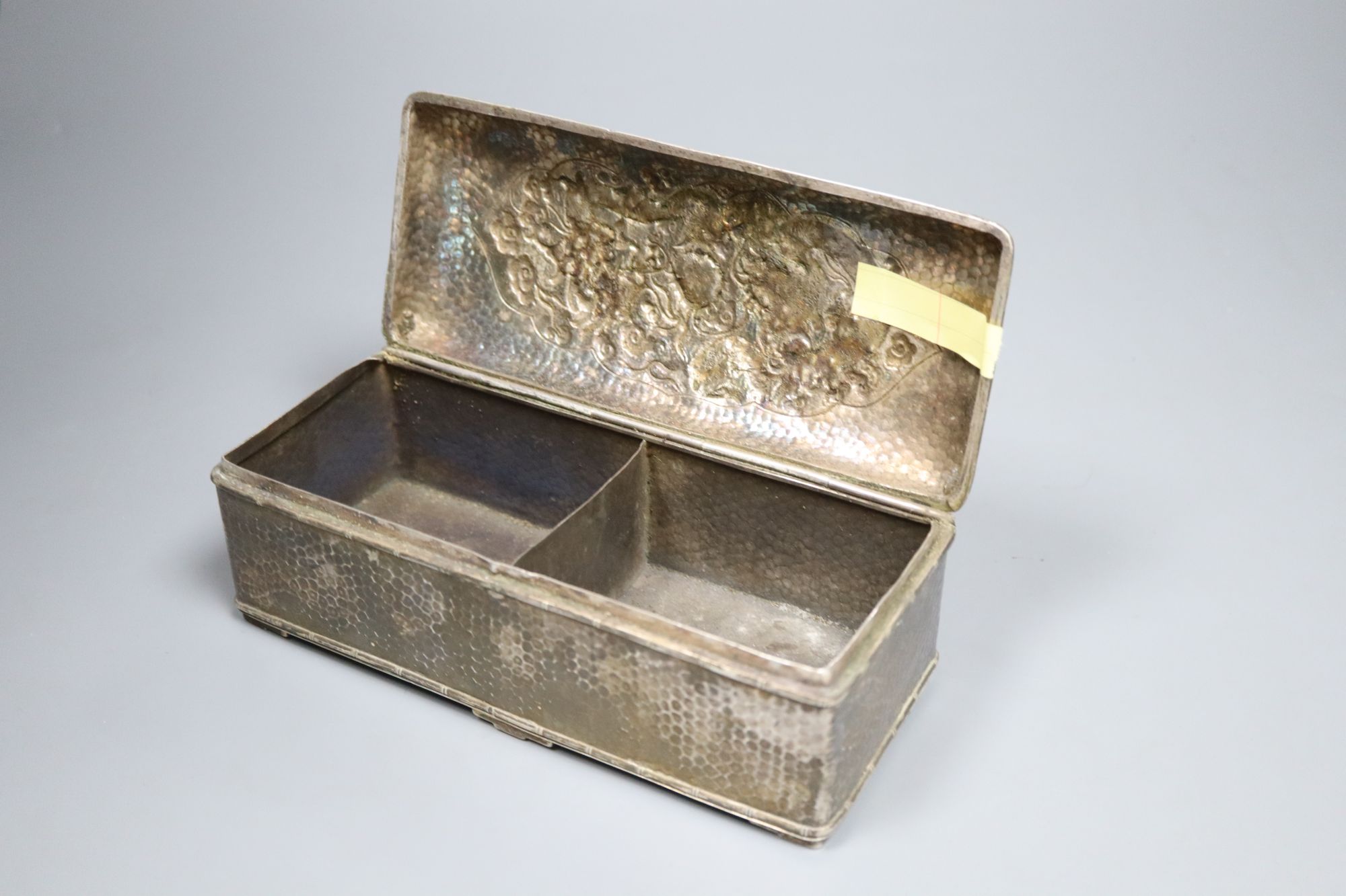 A Chinese planished silver casket, c.1900, with twin dragon decoration and divided interior, marks worn, 19cm